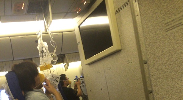 スコーク7700宣言の全日空37便で酸素マスクが出ている機内の写真画像