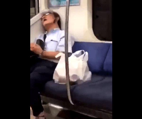 電車内で爆睡するおじさんの顔に蝉が止まっている動画のキャプチャ画像
